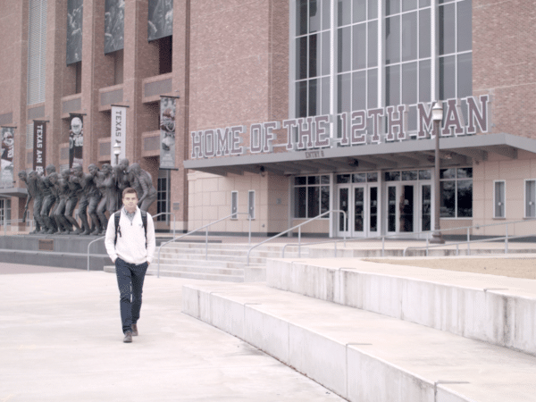 graduate student walking in front of kyle field